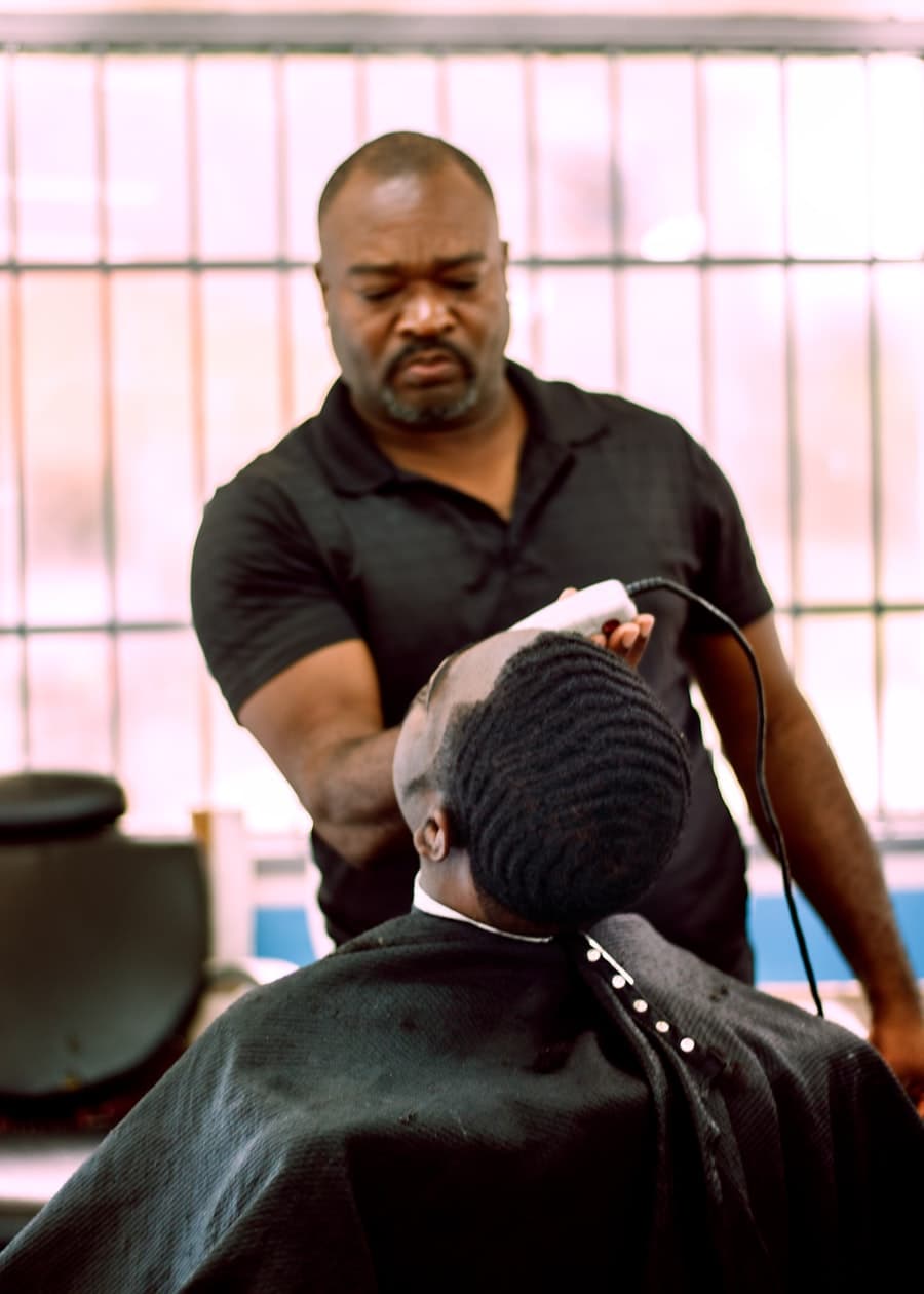 Barbeiro a cortar o cabelo a um cliente